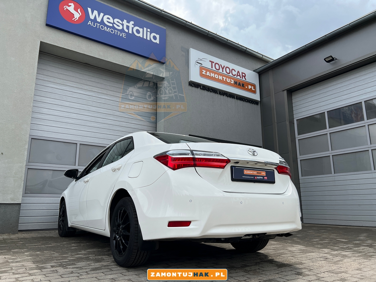 zdjecie z tylu z lewej strony samochodu toyota corolla po montazu haka holowniczego steinhof t-129 wyciecie w zderzaku niewidoczne